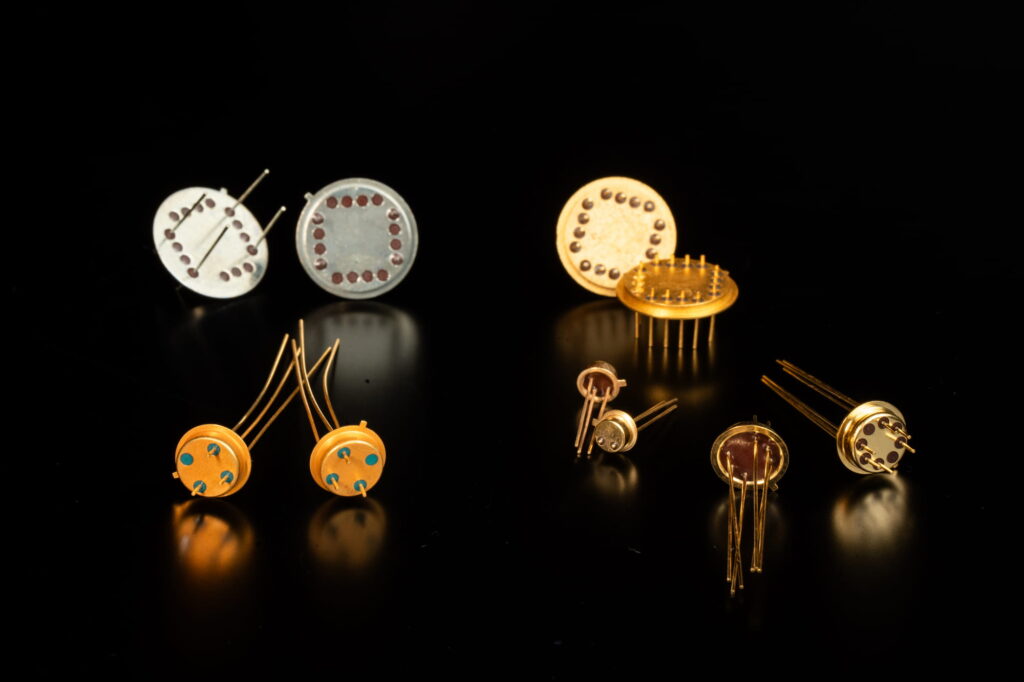 Assorted hermetic TO headers in multiple sizes and pin configurations, with nickel and gold plating finishes